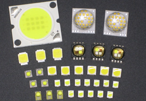 Image shows various LED package types side by side: from left to right a standard 5mm round LED, a rectangular LED, a surface-mounted SMD LED on a circuit board, a COB (Chip on Board) LED with multiple light points, and a high-power LED with a heatsink. E